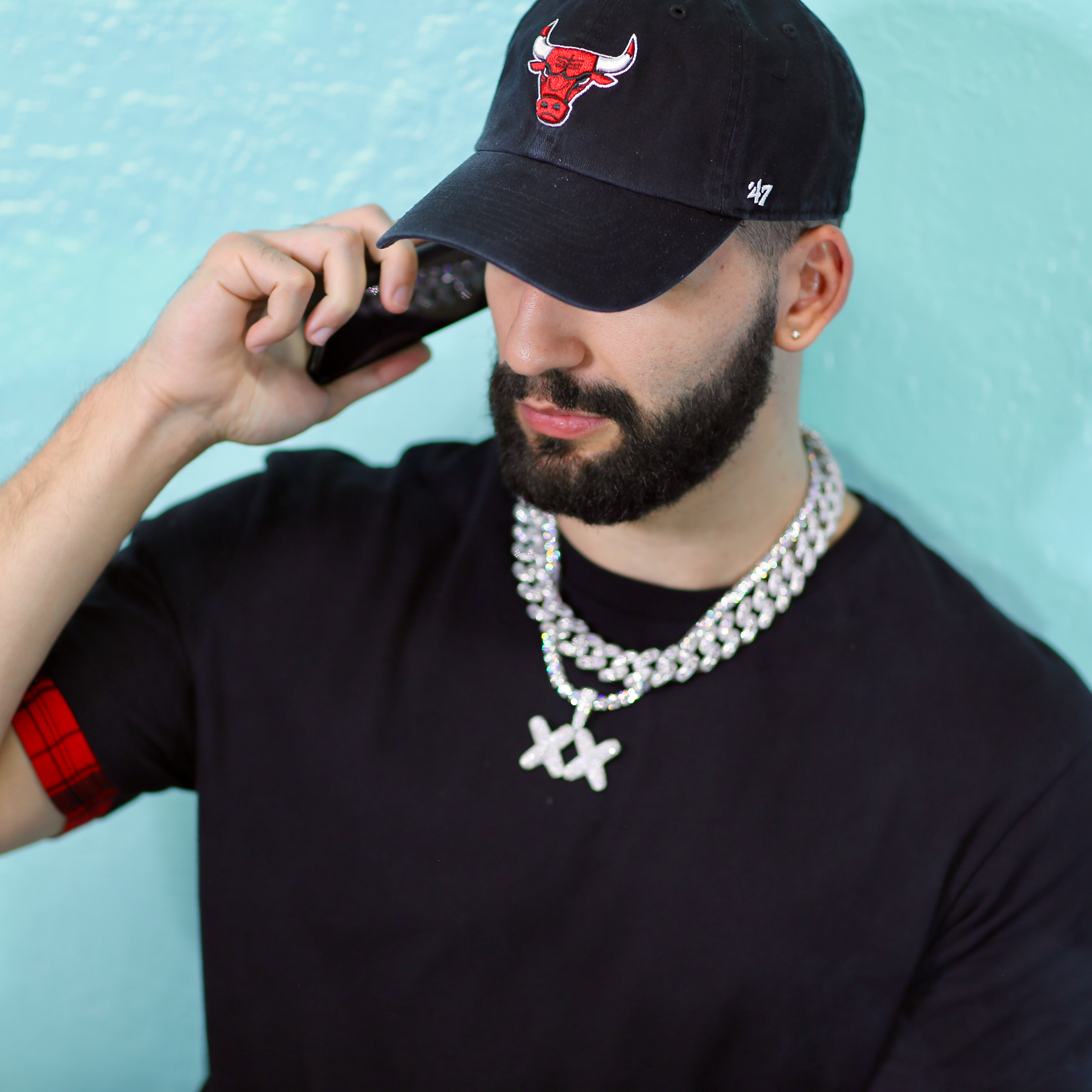 Male wearing white gold iced-out cuban link chain with cross pendant